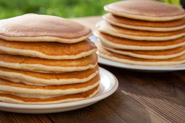 Close up pancakes. Stack of isolated american pancakes over wooden table. breakfast, food.