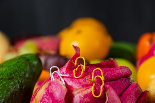 Close up paper clips white and yellow sitting on a dragon fruit and talking or having a conversation