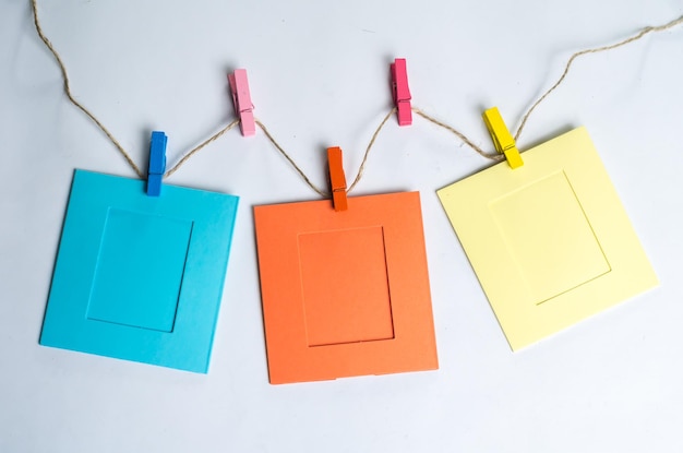 Close-up of paper picture frames hanging on white background