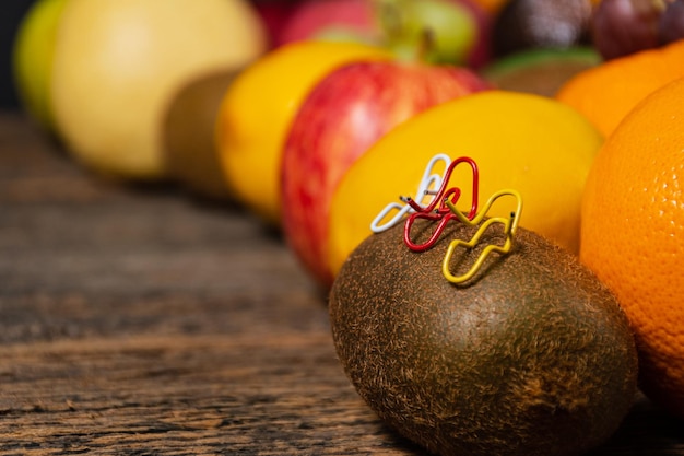 Close-up paperclips wit geel en rood zittend op een kiwi fruit met een gesprek