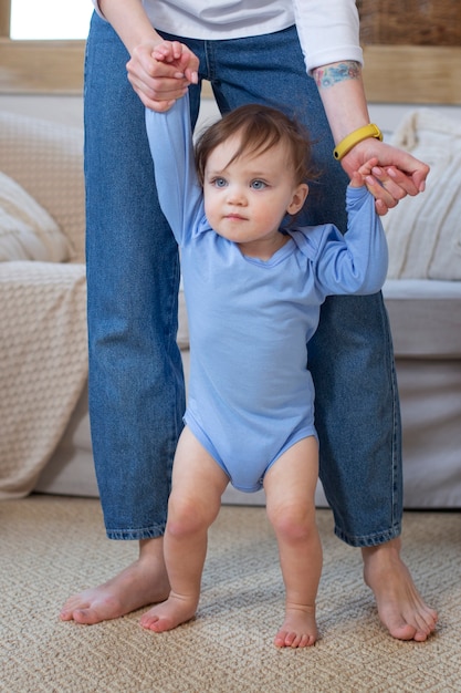 Chiuda sul genitore che tiene le mani del bambino sveglio