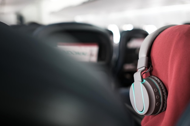 飛行機のキャビンでヘッドフォンをかけた乗客のクローズアップ