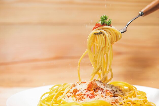 Foto close-up di spaghetti di pasta con salsa di pomodoro, olive e guarnizioni di cibo italiano