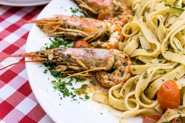 Foto close-up di pasta con gamberetti serviti in piatto su tavola