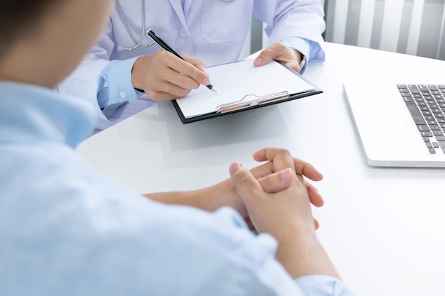 close up of patient and doctor taking notes in a hospital or clinic