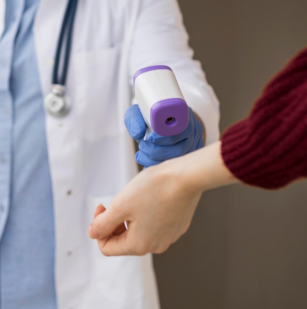 Photo close-up of a patient getting his temperature checked