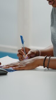 assignment help pictures Photo close up of patient signing checkup papers for examination in cabinet. young woman at healthcare consultation doing signature on medical documents while talking to doctor about treatment