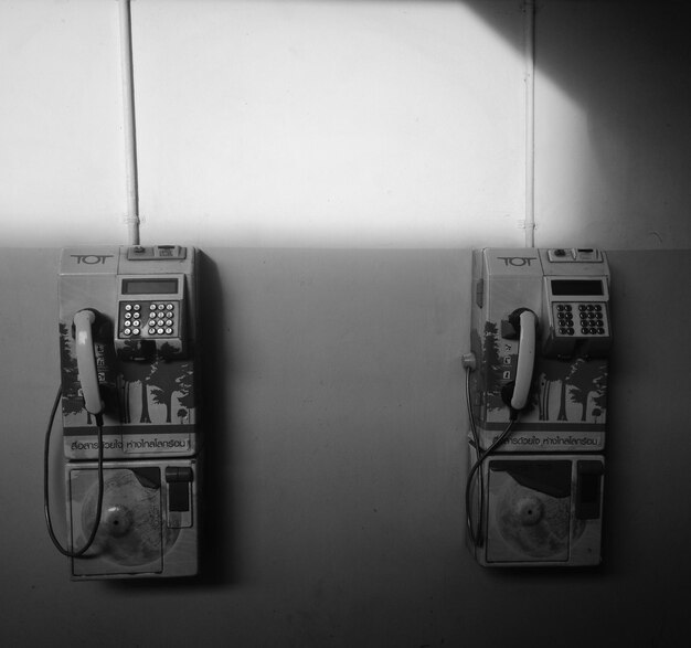 Photo close-up of pay phones in telephone booth