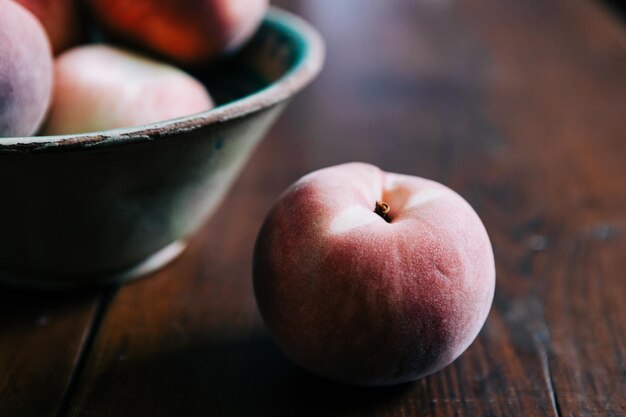 Photo close-up of peaches in bowl and on table