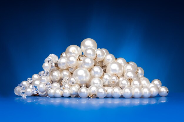 Close-up of pearl jewelry against blue background