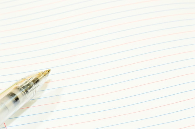 Близкий план ручки на пустой облицованной бумаге