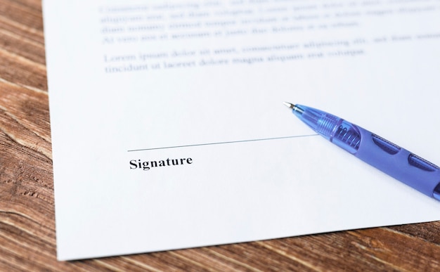 Close up of pen lying on a contract or application form to sign