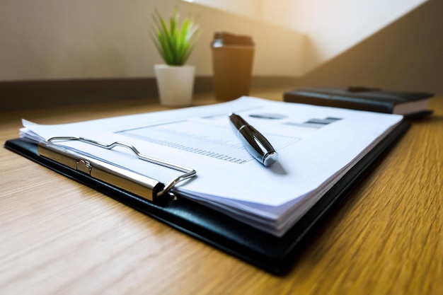 Photo close-up of pen with documents on table