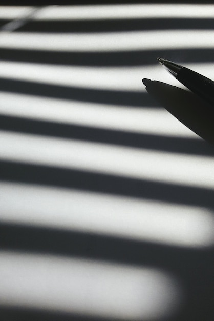 Photo close-up of pen with shadow on table