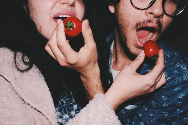close-up of people eating tomatoes