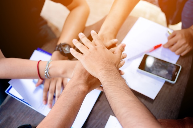 Close up of people putting their hands together