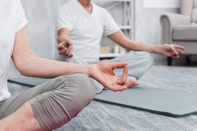 Primo piano delle mani della gente che lavora sul tappetino fitness