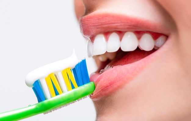 Close up of perfect and healthy teeth with toothbrush