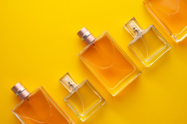 Close-up of perfume sprayers against yellow background