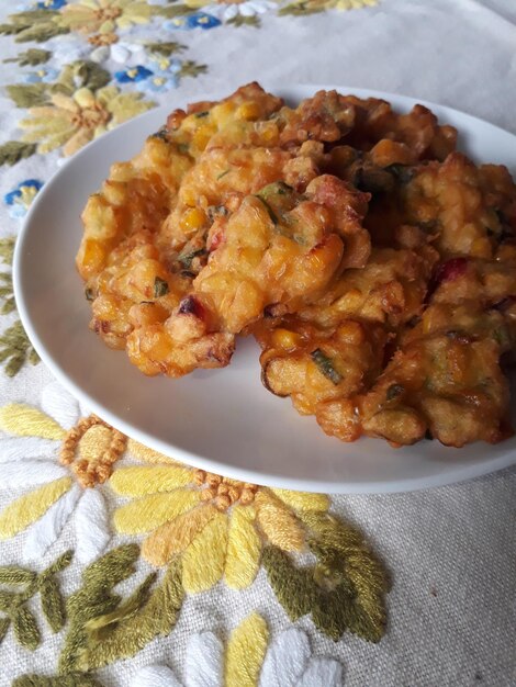 Close up of Perkedel Jagung or Bakwan Jagung Indonesian traditional corn fritters served on a white plate