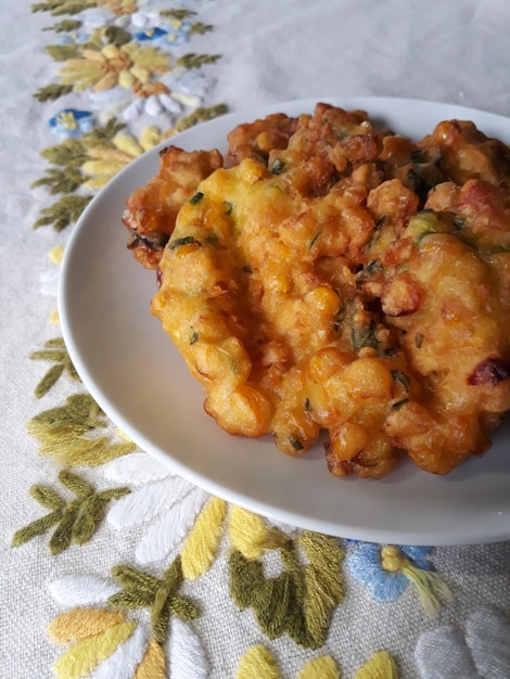 Close up of Perkedel Jagung or Bakwan Jagung Indonesian traditional corn fritters served on a white plate