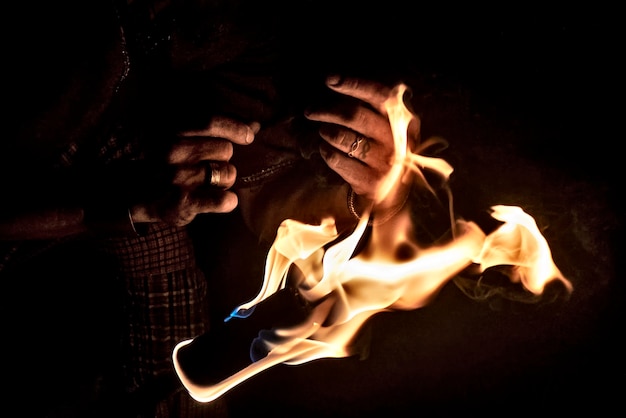 Foto prossimo piano di una persona al fuoco di notte