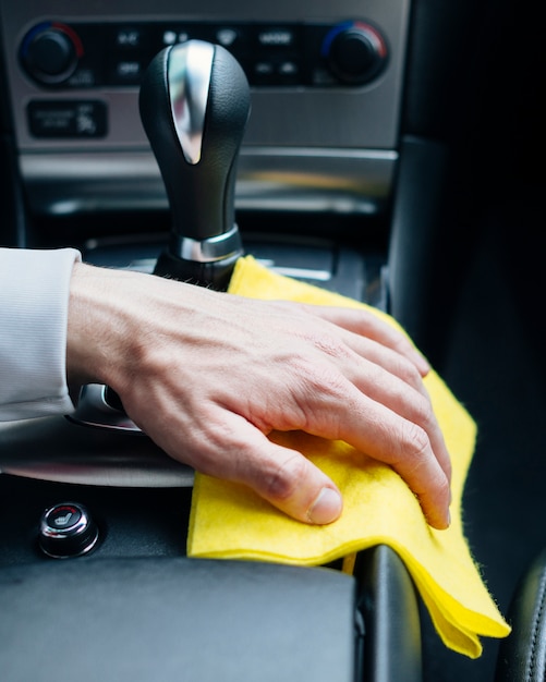 Foto chiuda in su della persona che pulisce l'interno dell'automobile