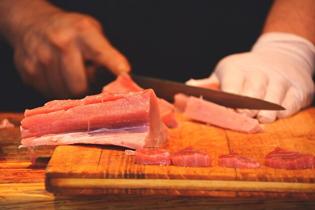 Photo close-up of person cutting meat