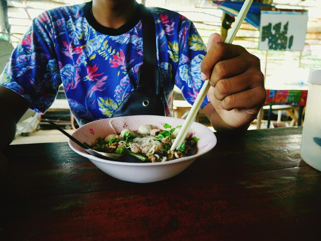 Photo close-up of person eating food on table