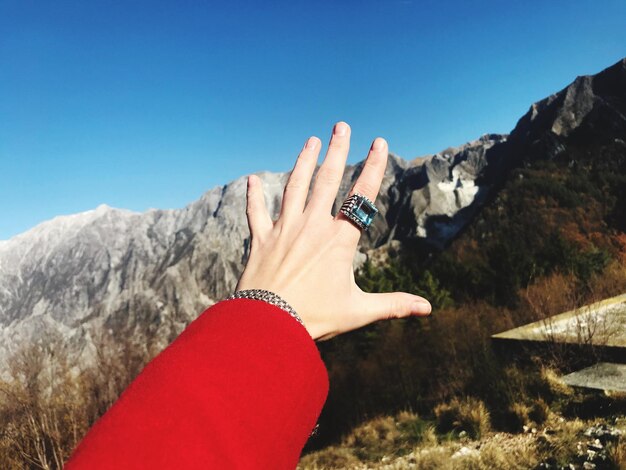 Foto primo piano della mano della persona contro il cielo limpido