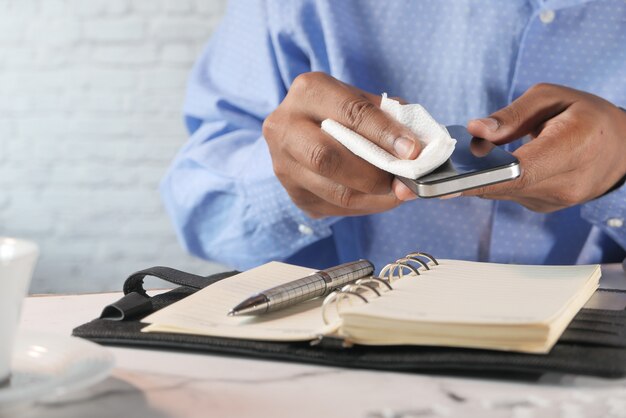 Close up of person hand cleaning smart phone.