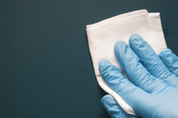 Close up of person hand cleaning table with cloth