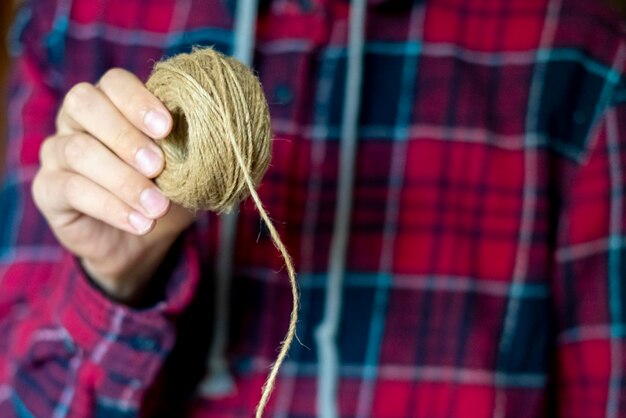 Close up person hand holding a rope ball roll f