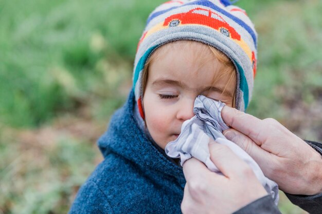 Close-up of person hands cleaning girl face