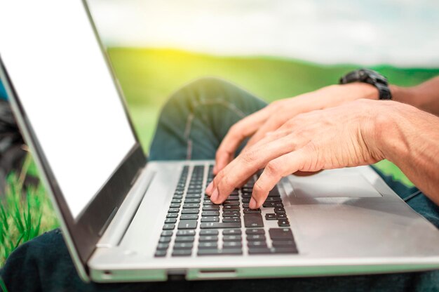 Close up of person hands on the laptop keyboard outdoors Closeup of a man's hands working on his laptop Side view of hands working on laptop