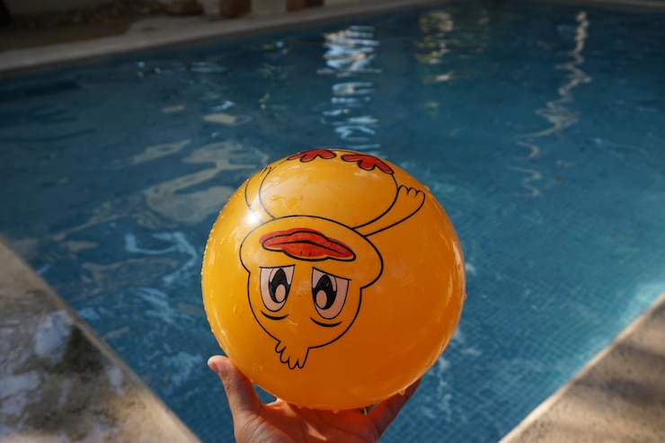 Photo close-up of person holding ball at swimming pool
