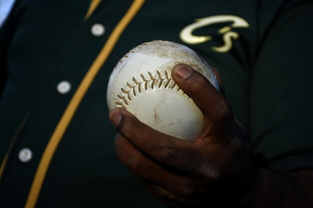 Photo close-up of person holding baseball ball