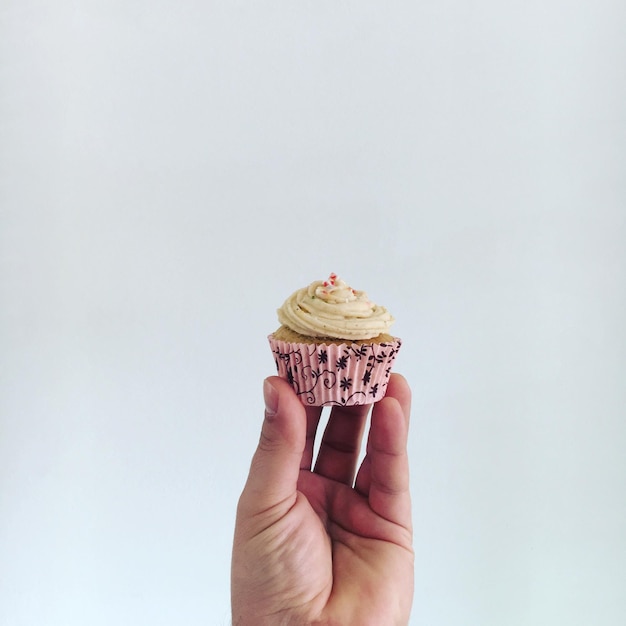 Photo close-up of person holding cupcake