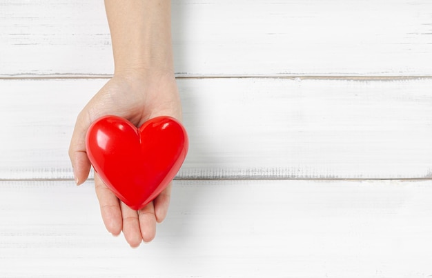 Close-up of person holding heart shape over table