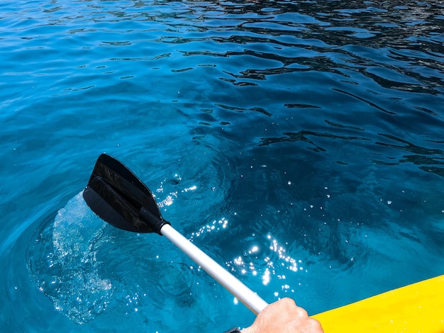 Photo close-up of person kayaking in sea