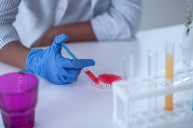 Close up of a person in a lab coat working with reagents