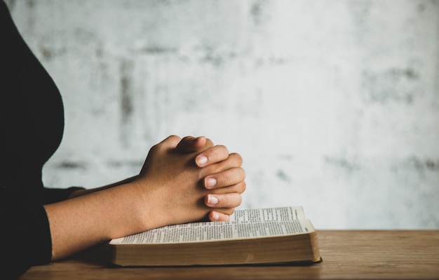 Close up on person praying near the bible