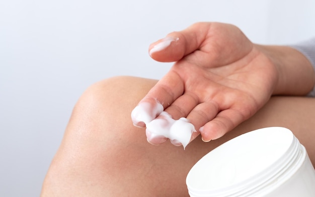 Close up of a person rubbing cream for healing injured knee joint Bruise on the knee Leg pain