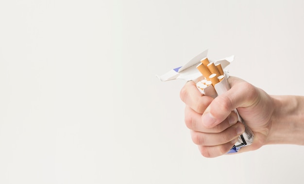 Close-up of a person's hand creasing cigarettes and box