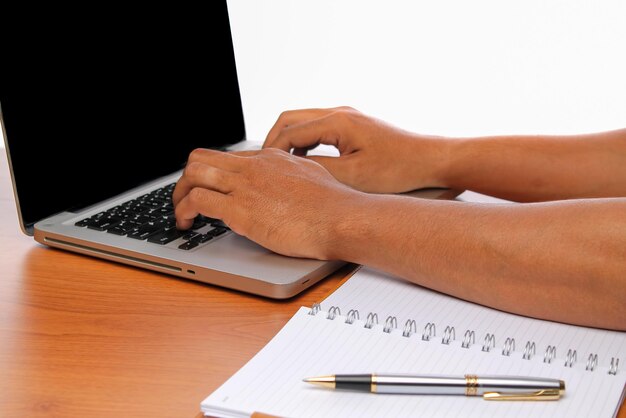 Photo close-up of person using laptop on table over white background