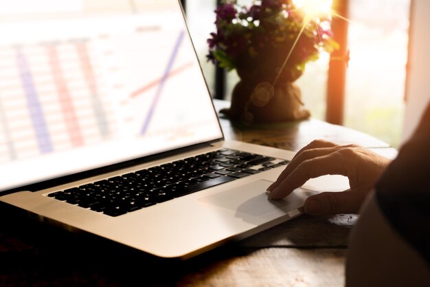 Photo close-up of person using laptop on table