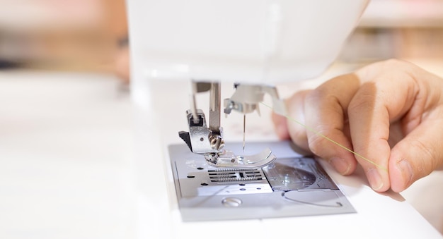 Close-up of person using sewing machine