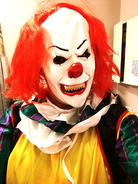 Photo close-up person wearing clown mask