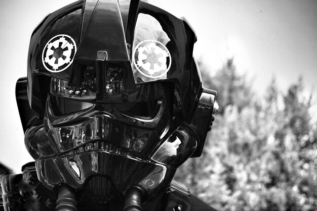 Photo close-up of person wearing gas mask against sky