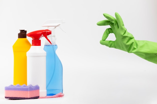 Photo close-up person with green glove and cleaning products